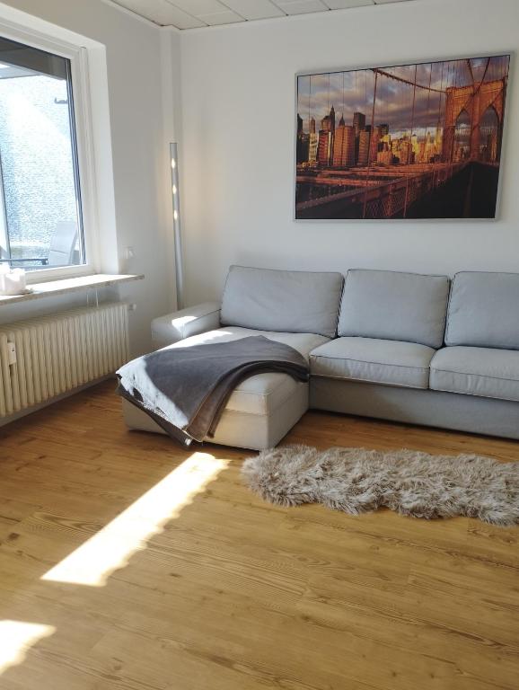 a living room with a couch and a window at Frisch saniertes Apartment am Falderapark in Neumünster
