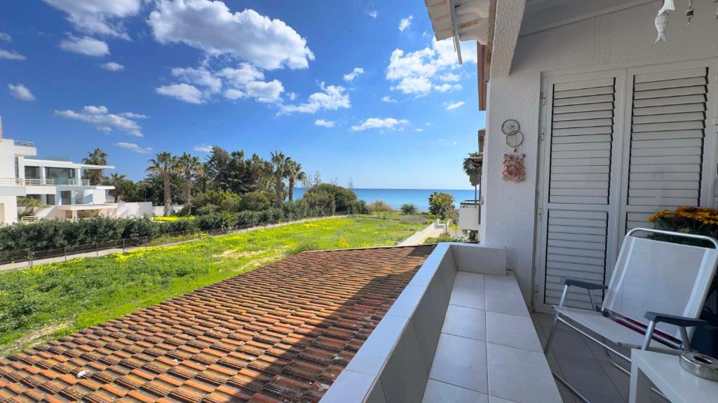 a balcony with a view of the ocean at Sundy Beach Seaview 2BDR Larnaka Dhekelia in Larnaca