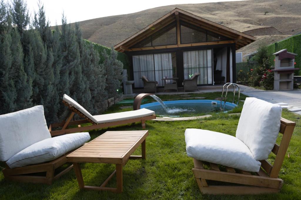 a backyard with chairs and a pool with a gazebo at Eymirbungalovya in Yeşilkent