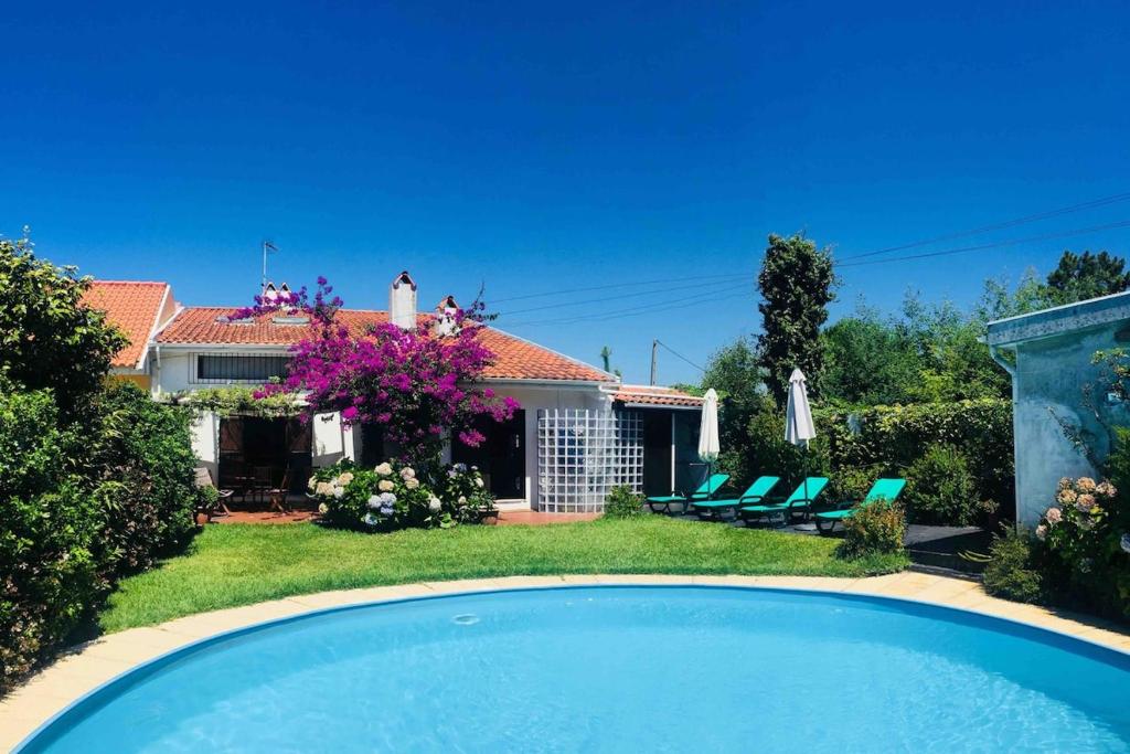 a house with a swimming pool in front of a yard at Casa de praia com piscina in Árvore