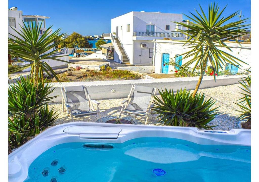 a swimming pool with palm trees and a building at Pier's House in Pollonia