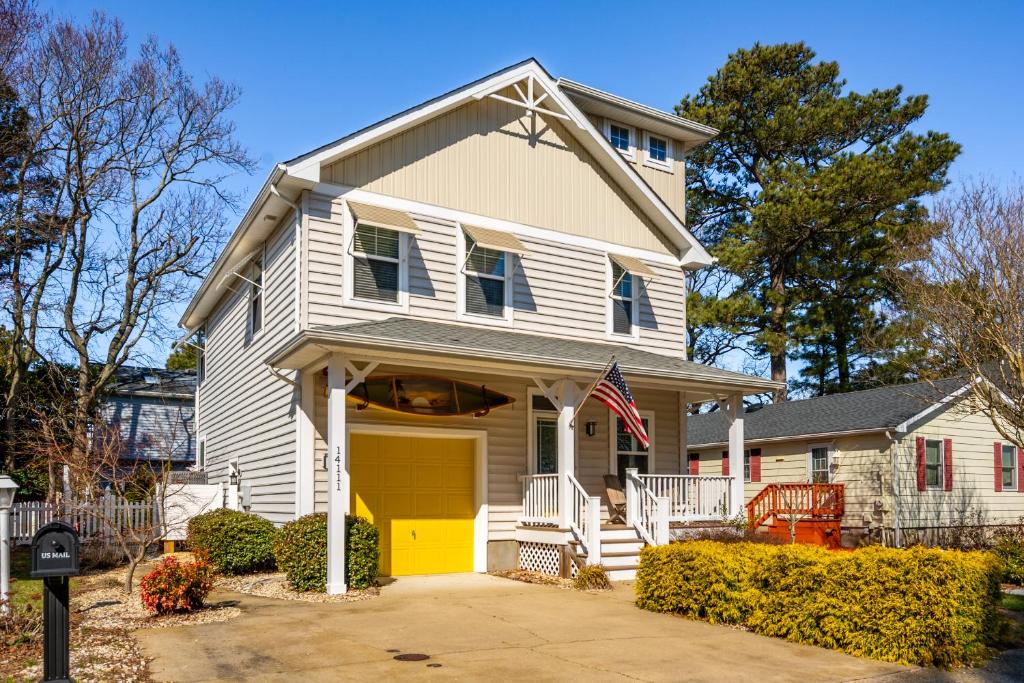 a white house with a yellow garage at 14111 Fiesta Rd - Cape Canoe in Ocean City