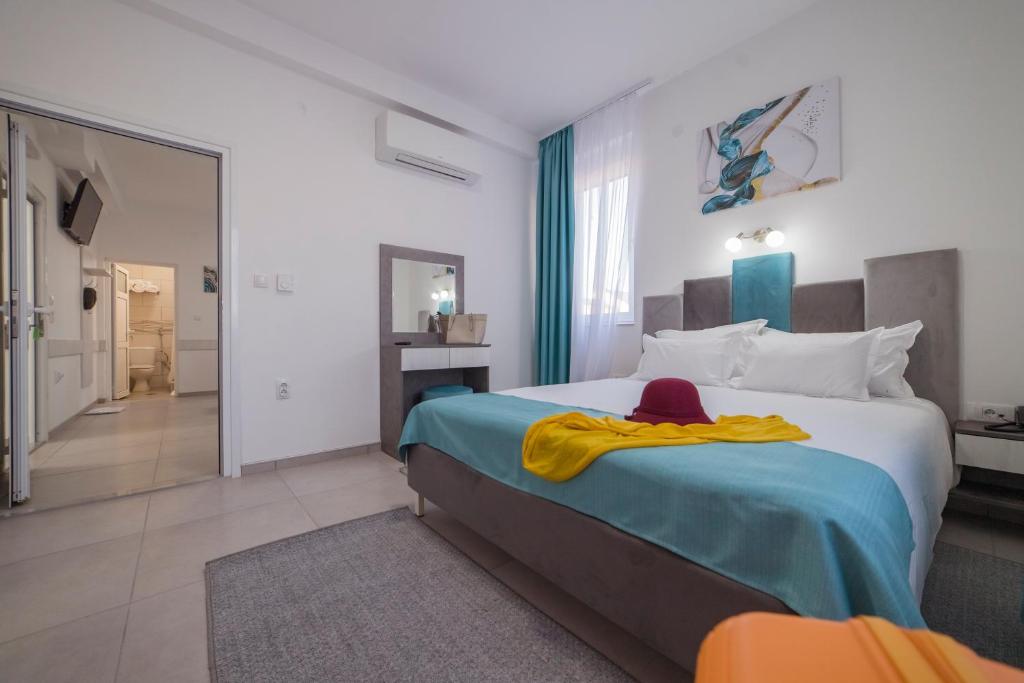 a bedroom with a large bed with a red hat on it at AS APARTMANI PIROT in Pirot
