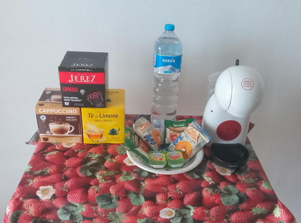a table topped with strawberries and a bottle of water at Hotel Rustichello in Marina di Campo