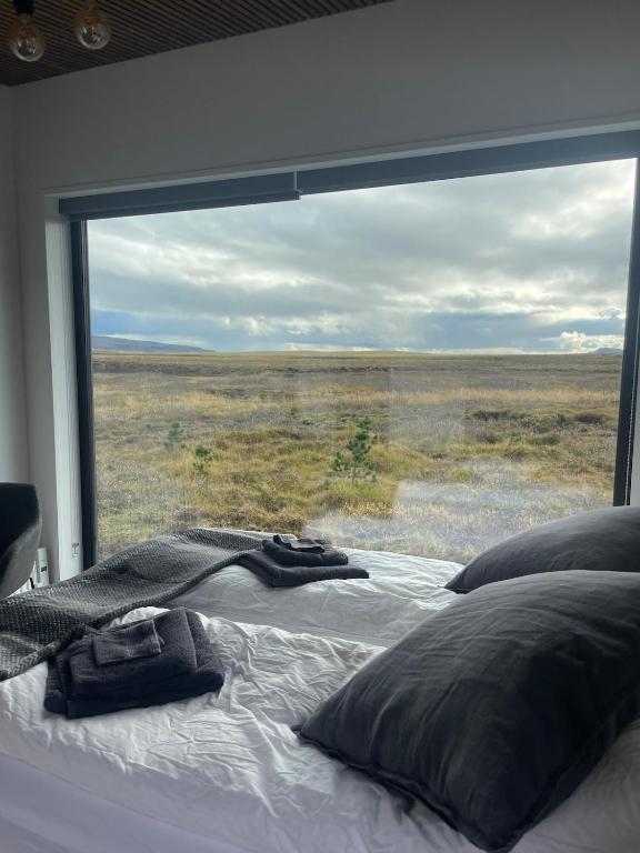 a bed in a room with a large window at Golden Circle Panorama Chalet in Selfoss