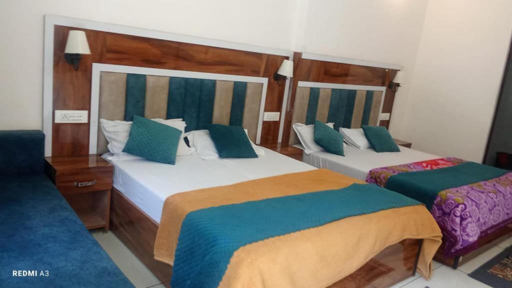 a bedroom with two beds with blue and orange sheets at trigun pahadi hub in Uttarkāshi