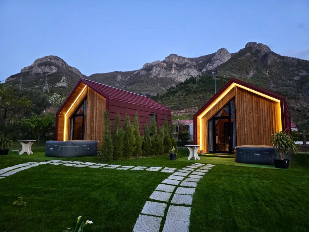 a house in a field with mountains in the background at Dalmace Villas in Koman