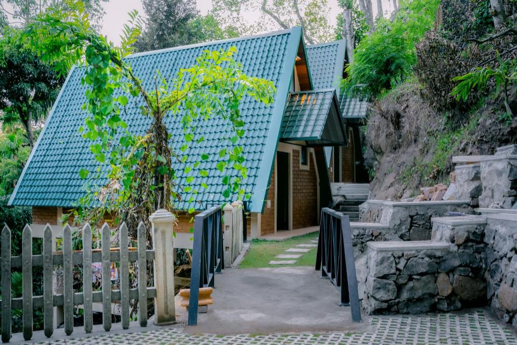 a house with a blue roof and a fence at Brilliant View Cottages in Ella