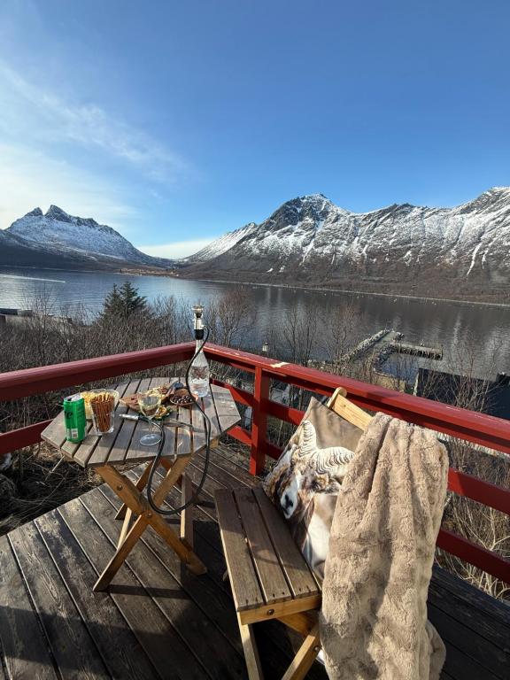 a picnic table on a deck with a view of a lake at Rifi Senja House in Senja