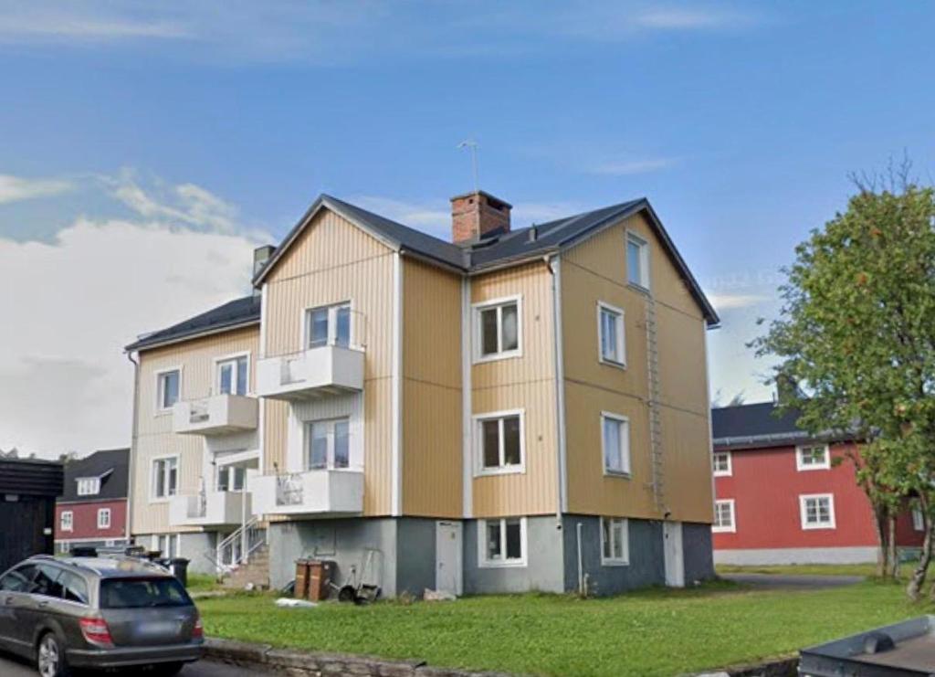 a large building with a car parked in front of it at Aurora Apartments in Kiruna