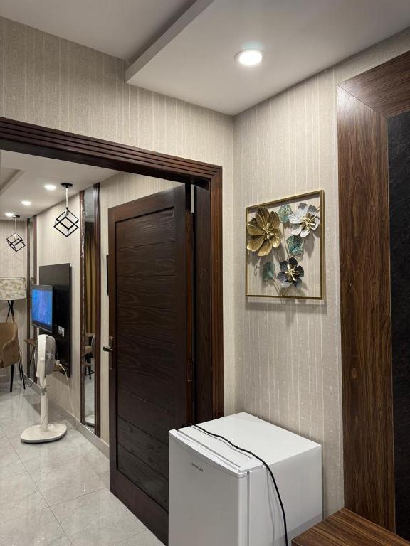 a bathroom with a toilet in a room with a door at Stayease in Lahore