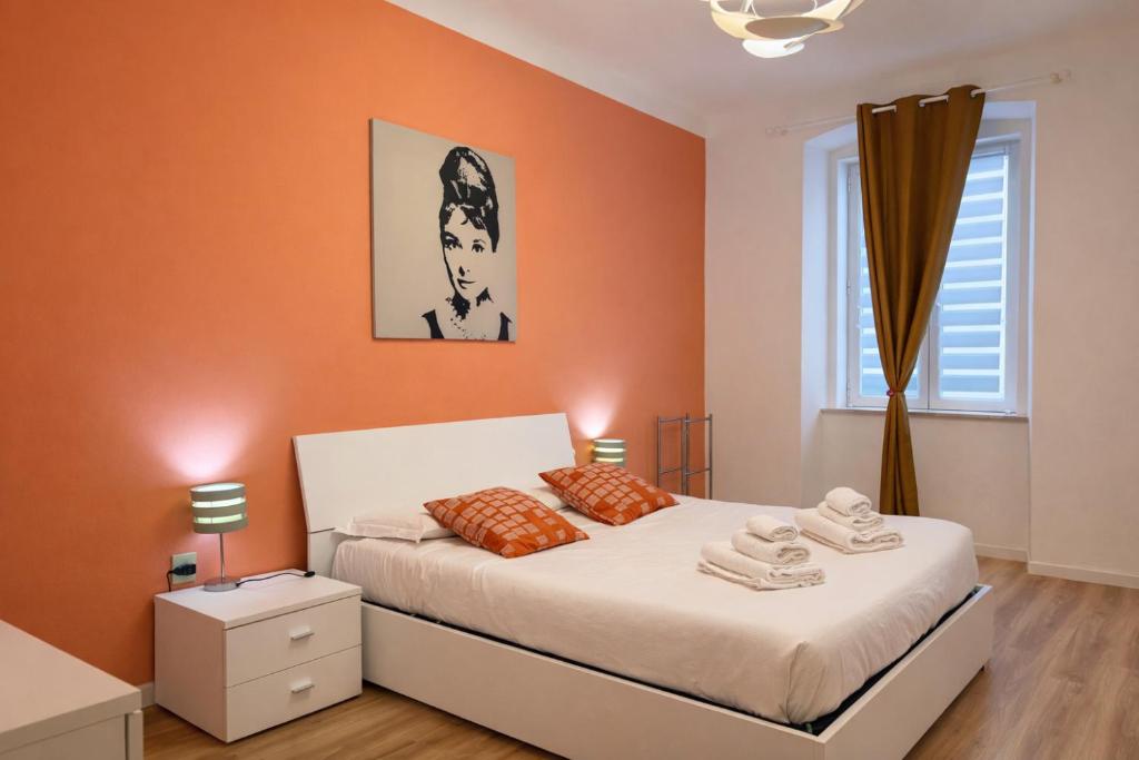 a bedroom with a bed with orange walls and a window at La casa di Sally - Silenzioso Bilocale in centro in Trieste