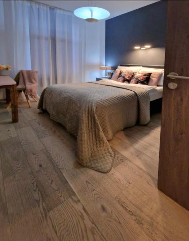 a bedroom with a large bed with a wooden floor at Pension Villa Grün in Zwickau