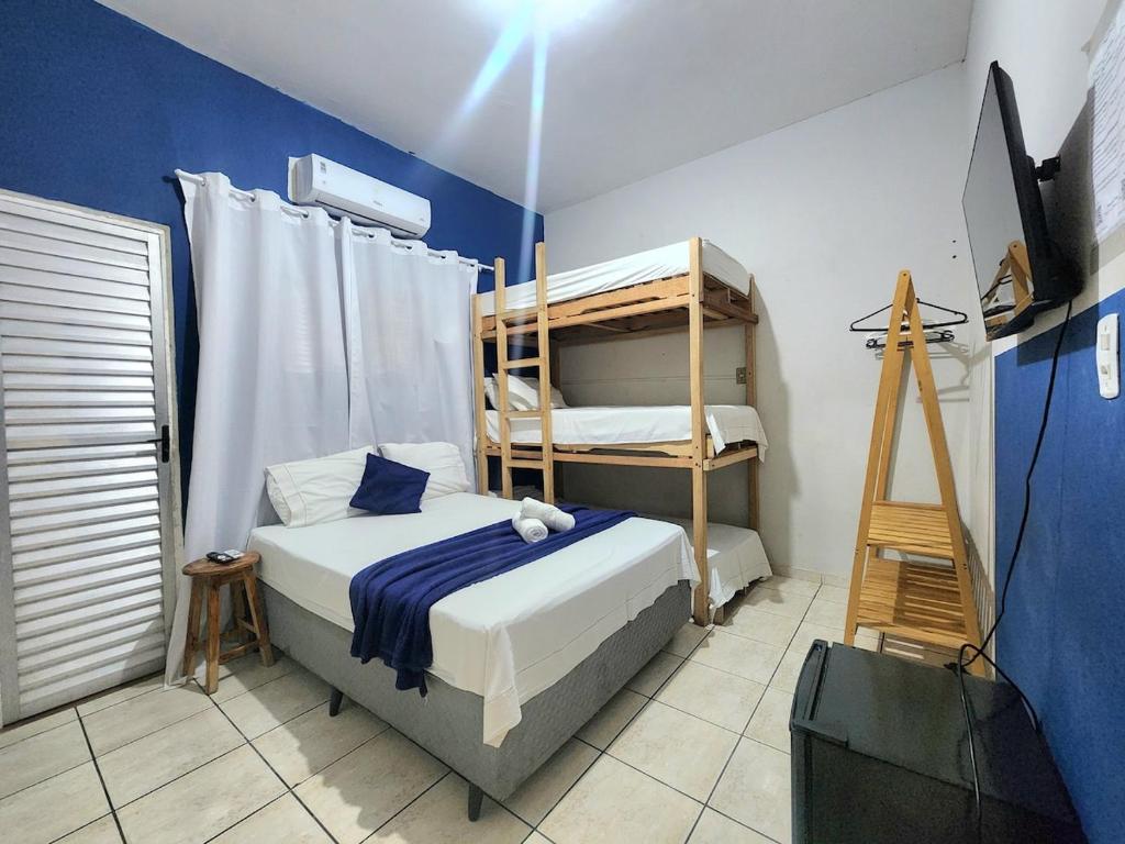 a bedroom with two bunk beds and a television at Mini Hostel no centro de Tutoia in Tutóia