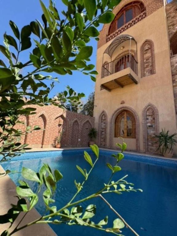 a house with a swimming pool in front of it at Sahari house in Al Aqālitah