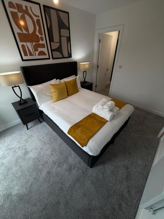 a bedroom with a large bed with yellow pillows at Berkeley Square Apartments by StaySavvy Accommodation in Manchester