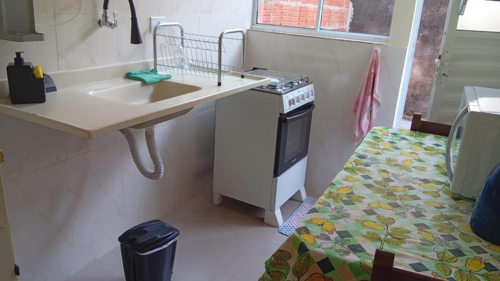 a small kitchen with a sink and a stove at Kitnet 03 Lunardi Campinas in Campinas