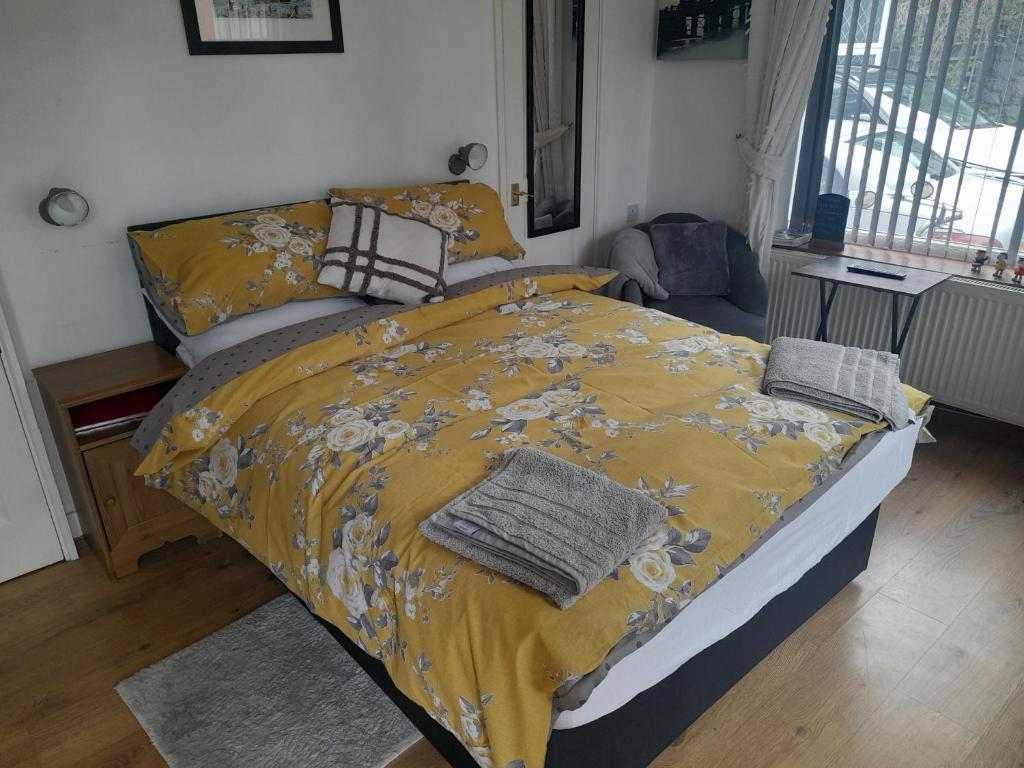 a bedroom with a bed with a yellow comforter at The Bolt Hole in Barmouth