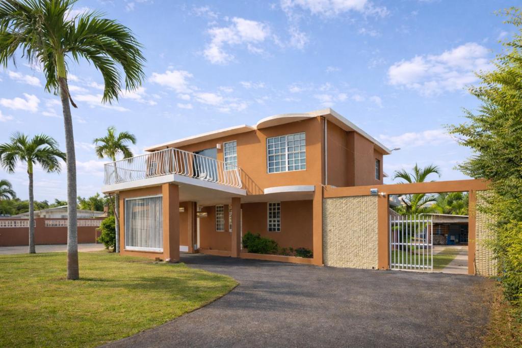 a large house with palm trees in front of it at Dorado Costa De Oro Beach 2 Bedroom Oceanfront by Rentalspr in Dorado