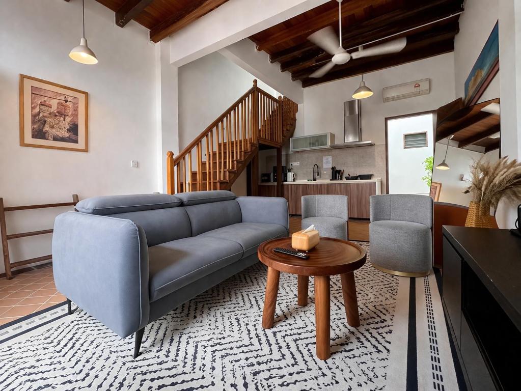 a living room with a blue couch and a table at Courtyard by Heritage Row in George Town