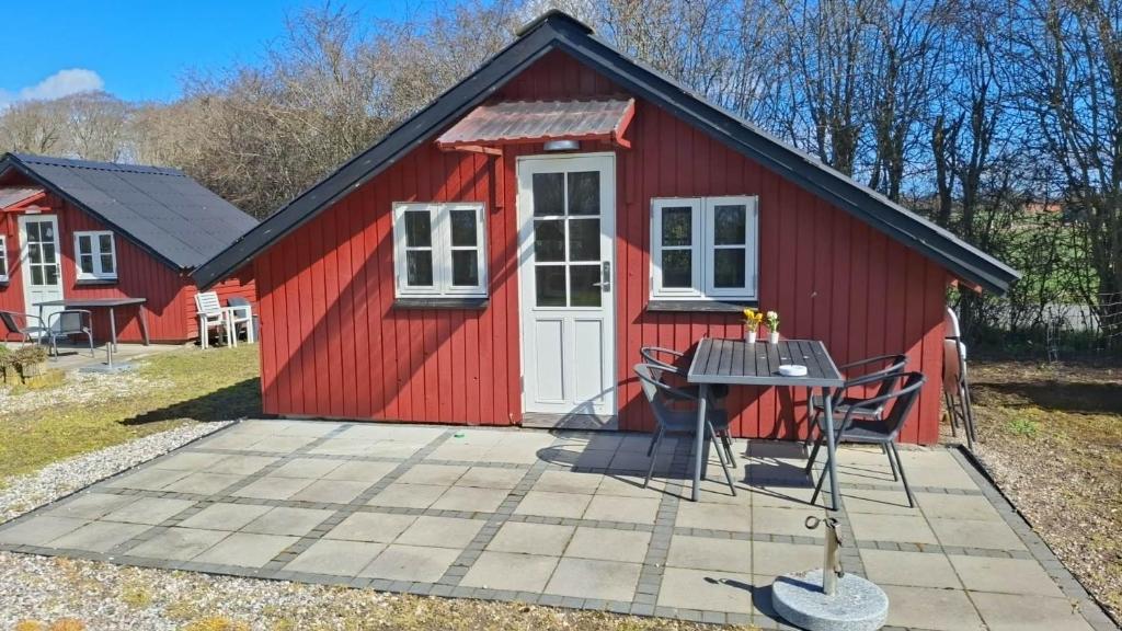 a red tiny house with a table and chairs at Tåsinge camping og Grill in Svendborg