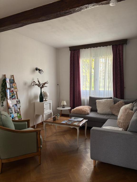 a living room with a couch and a table at Maison chaleureuse de village - location logement entier in Lanans