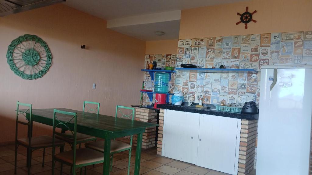 a dining room with a green table and chairs at Flat Casa Taiba 2002 in São Gonçalo do Amarante