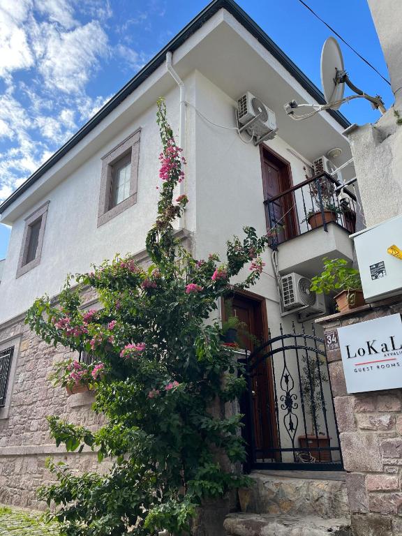 a building with flowers on the side of it at Lokal Ayvalık Guest House in Ayvalık