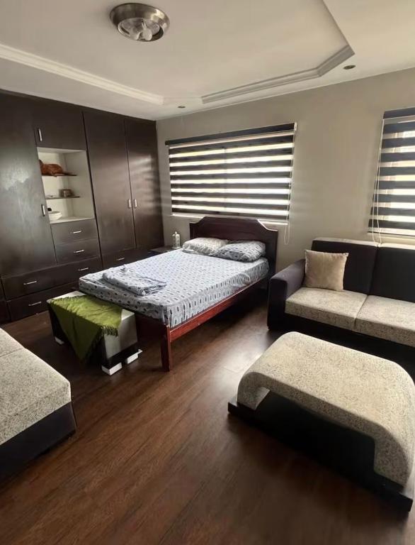a bedroom with a bed and a couch in a room at Or King in Cuenca