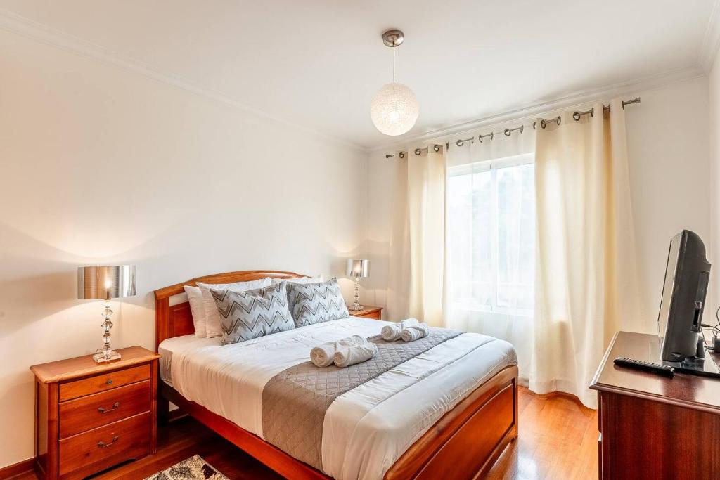 a bedroom with a bed with two towels on it at Sardonyx Scape Madeira Close to Garajau Funchal in Caniço