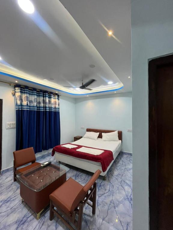 a bedroom with a bed and a table and a couch at Hotel Golden Palace in Chhatarpur