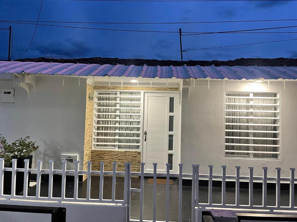 a white house with a fence in front of it at Casa Roldanillo in Roldanillo