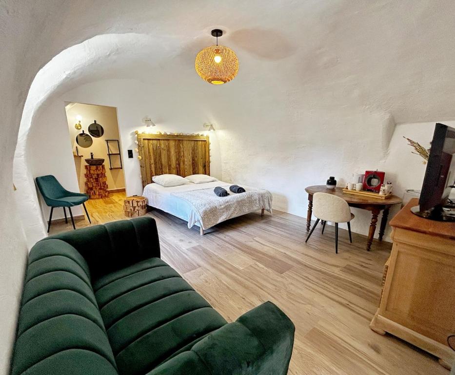 a living room with a bed and a couch at Le petit refuge in Allos