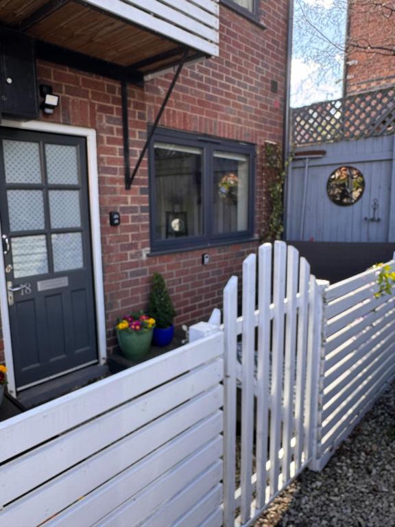 a white picket fence in front of a house at The Lazy Fox, Shrewsbury in Shrewsbury