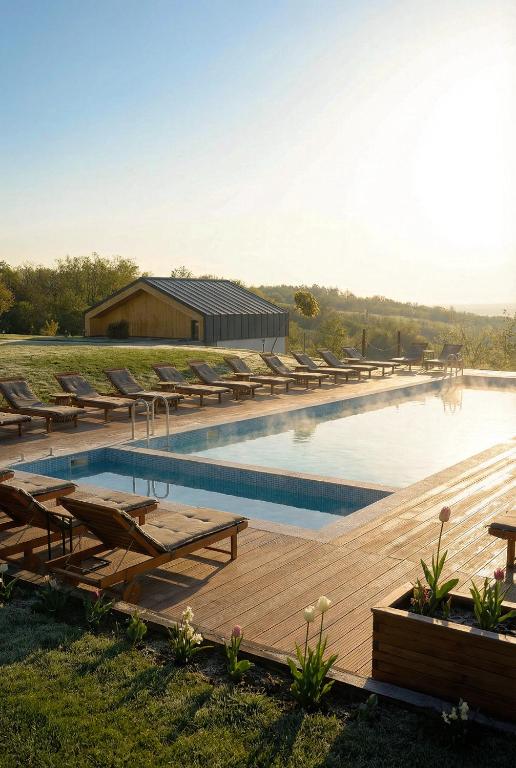 a swimming pool with chairs and a wooden deck at Zen Resort & SPA in Purcari