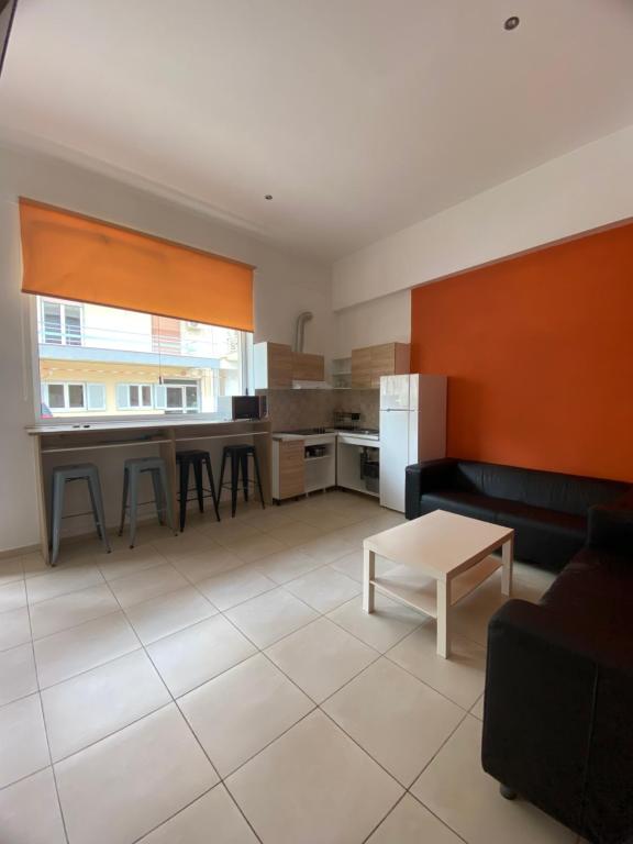 a kitchen with a couch and a table at Corinth Beach Apartment and Hostel in Korinthos