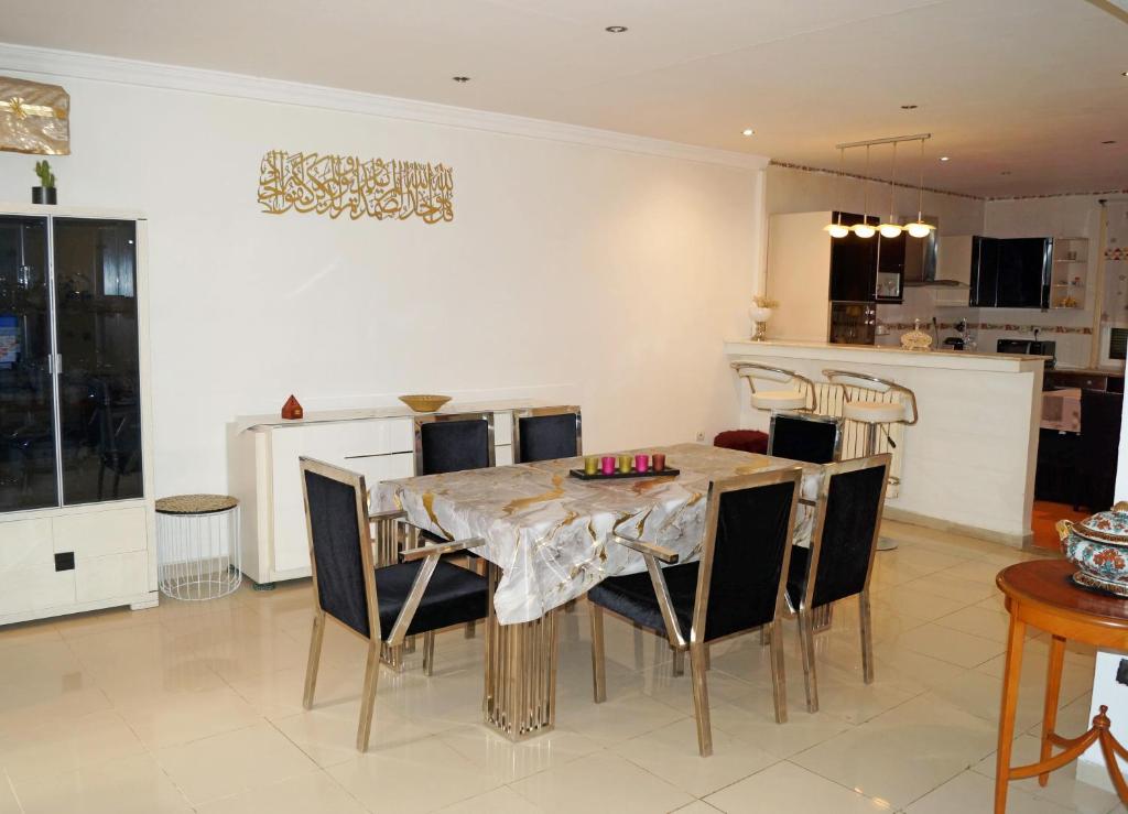 a dining room with a table and chairs at Duplex T3 résidence Djnen el Bey in Annaba