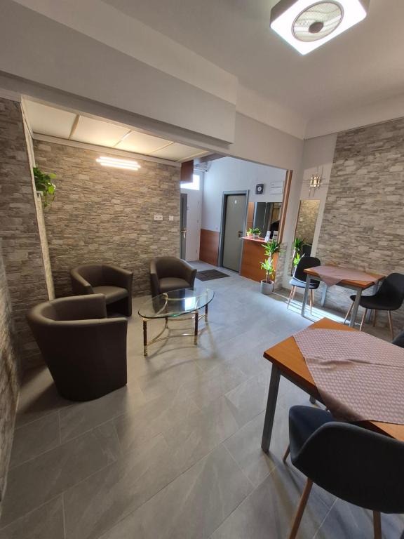 a lobby with chairs and tables and a brick wall at Eitans Guesthouse in Budapest