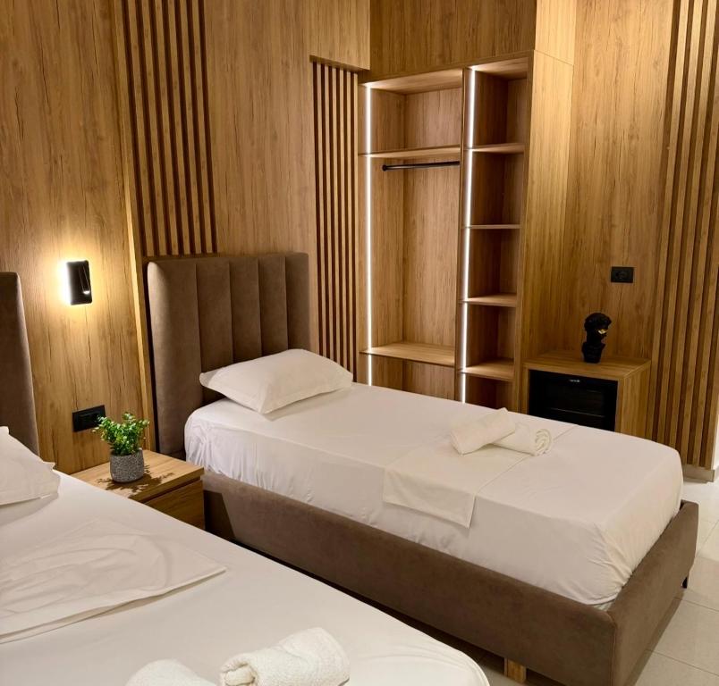 a bedroom with two beds and a book shelf at Vila Llaman Luxury Rooms in Himare