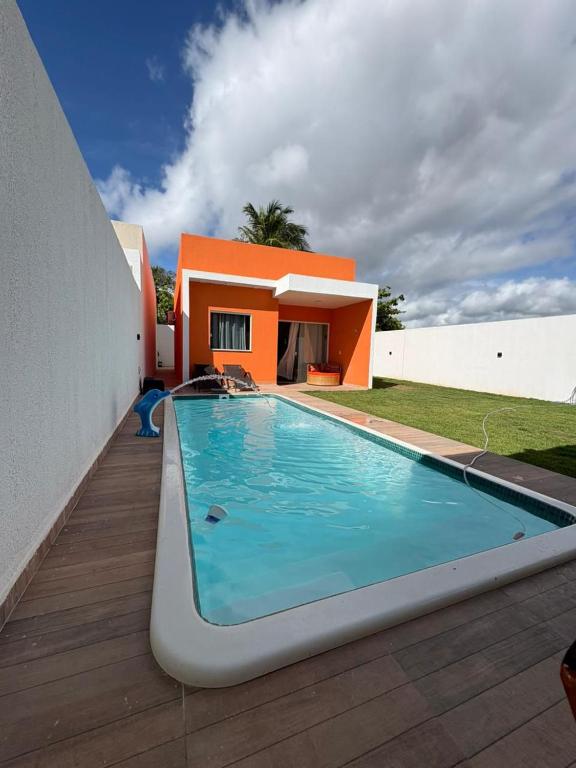a swimming pool in front of a house at Cantinho Jauá 3 in Camaçari