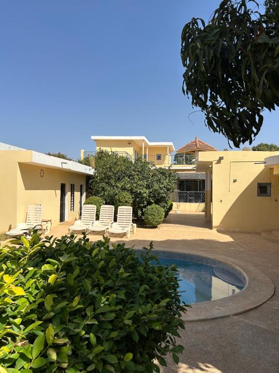 a house with a swimming pool in a yard at Villa & Appartement Du Soleil Ngaparou in Ngaparou