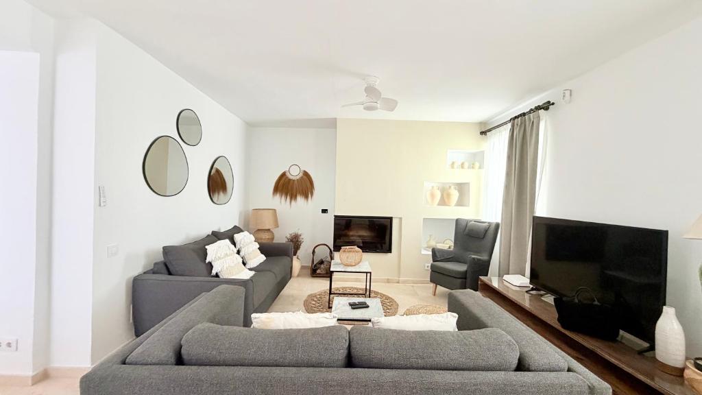 a living room with two couches and a tv at TarifaMiCasa Amor de Dios in Tarifa