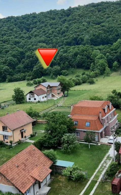 a red kite flying in the air over houses at Quiet apartment in Hadžići