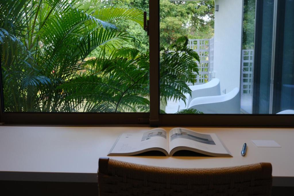 a book sitting on a table in front of a window at ERUMAYA Resort in Motobu