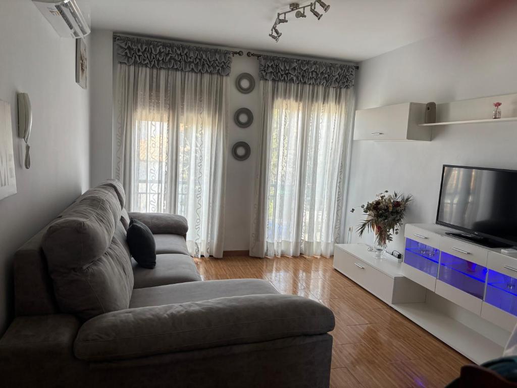 a living room with a couch and a flat screen tv at Capricho in Burunchel