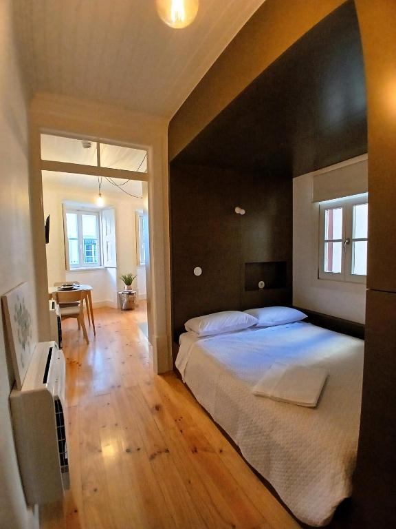 a bedroom with a large bed and a table at Green View Studios Coimbra in Coimbra