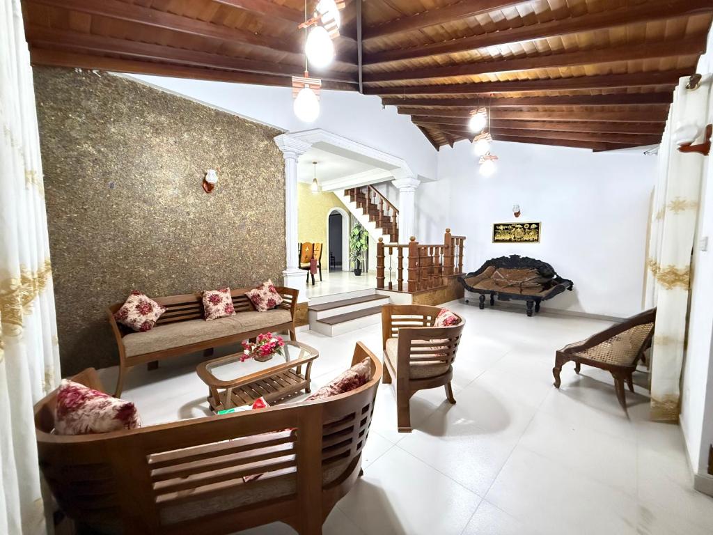 a living room with chairs and a couch and a table at Arora Villa in Digana