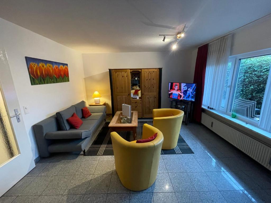 a living room with a couch and chairs and a tv at Fewo 2 EG Sylt Westerland in Süderende
