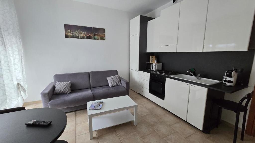 a small living room with a couch and a kitchen at Faraboni Apartments in Novara