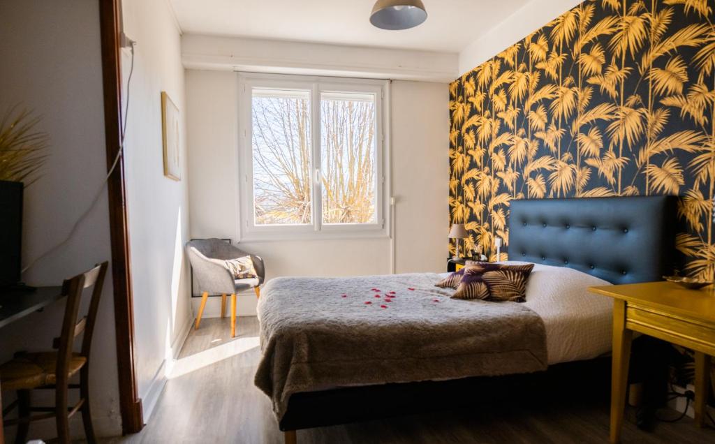 a bedroom with a bed with a blue headboard and a window at LA MAISON DE BARLEST - LOURDES in Barlest